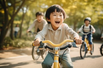 Happy asian kid riding bicycle in the park