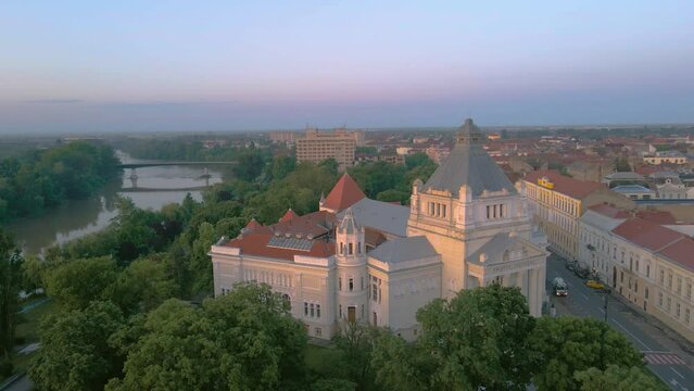 Aerial footage over Arad city center at sunrise, with the Cultural palace in the view. Video was shot from a drone, in the morning, while flying around the building with camera level.