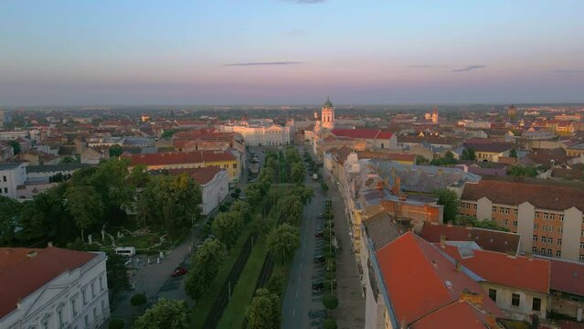 Aerial footage over Arad city center with theatre and Catholic Cathedral in background. Video was shot from a drone, in the morning, while banking left, above the main boulevard, with camera level.