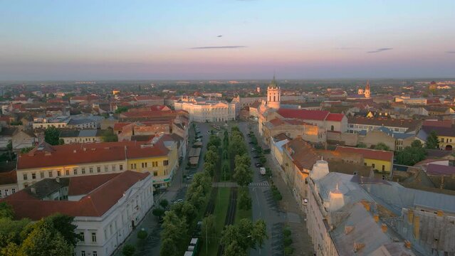 Aerial footage over Arad city center with theatre and Catholic Cathedral in background. Video was shot from a drone, in the morning, while flying forward, above the main boulevard, with camera level.