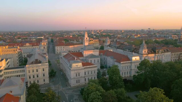 Aerial footage over Arad city center with the Cultural palace and Administrative palace in the view. Video was shot from a drone, in the morning, while flying backwards with camera level.