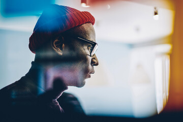Side view of serious african american hipster guy pondering on idea and looking at window