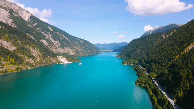 Aerial footage of the beautiful Achen Lake in Tyrol, Austria. Video of the lake was shoot from a drone while flying forward, from above. In the footage can be seen the lakes blue color and mountains.