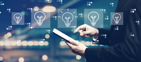Idea light bulb theme with businessman using a tablet computer