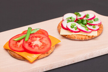 Different Cracker Sandwiches with Tomato, Cucumber, Radish and Cheese on Cutting Board. Easy Breakfast. Diet Food. Quick and Healthy Sandwiches. Crispbread with Tasty Filling. Healthy Dietary Snack