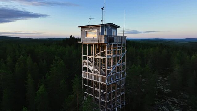 Aerial view rotating toward a watchtower, sunny, summer sunrise in Scandinavia