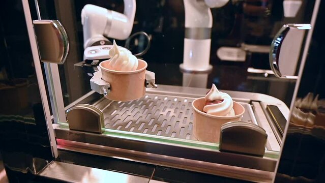 A Robo hand is serving the ice cream cups, robot chef footage