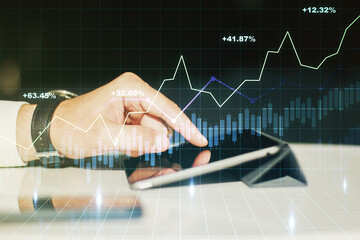 Double exposure of abstract creative financial chart with finger clicks on a digital tablet on...