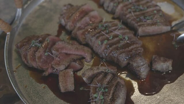 Carne de ternera cocida a medias sobre plato para servir.  Toma cerrada HD.