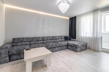 A modern room in a new apartment with a minimum set of furniture
