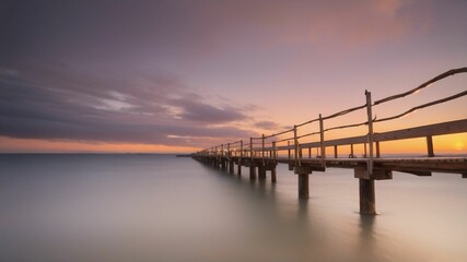 Fototapeta na wymiar long pier stretching into the ocean at sunset