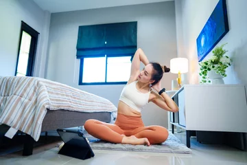 Tuinposter Portrait of cheerful healthy sporty fitness Asian woman doing yoga shoulder stretching in living room at home .healthy stock photo. © mnirat