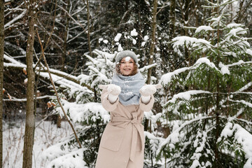 Cute girl throws snow on the street