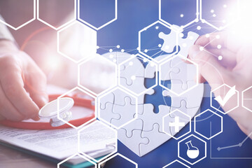 Stethoscope, puzzle heart, prescriptions. Double exposure in composition. Doctor`s desk in the clinic's office.