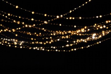 Gold Twinkle Christmas string lights on black background. Defocused Glowing light bulb garland. Generative AI - obrazy, fototapety, plakaty