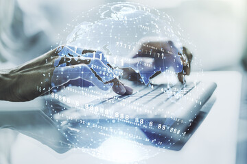 Abstract creative coding concept with world map and hands typing on laptop on background....