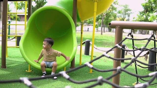 Child Playing at the Park on the Playground for Kids,Children playing at an outdoor playground kids having fun at the park