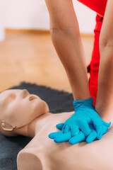 Chest compression techniques in a CPR first aid training with a dummy.