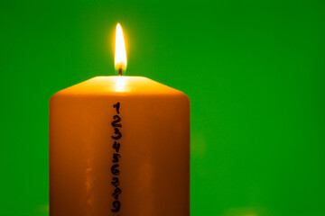Candle with advent calendar on green chroma key background Traditional Burning Christmas Wax...