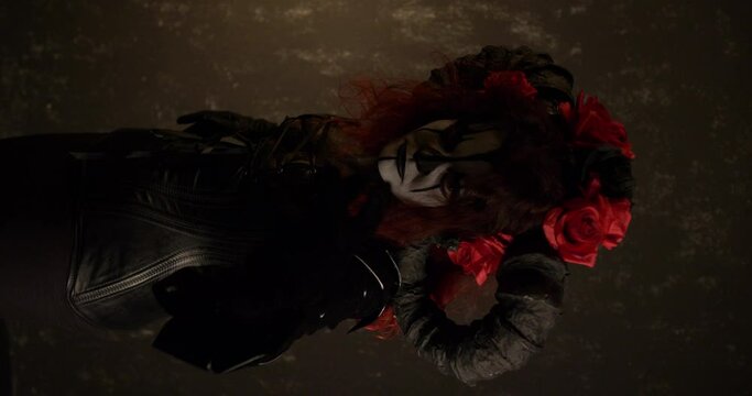 Catrina Cosplay girl moving closer to the camera with a Domina outfit and Dark background , Medium Close up