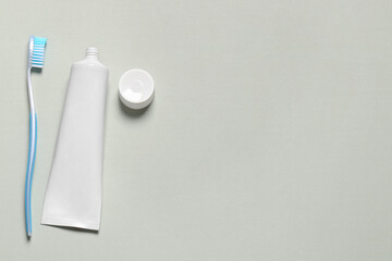 Plastic toothbrush and paste on white background, flat lay. Space for text