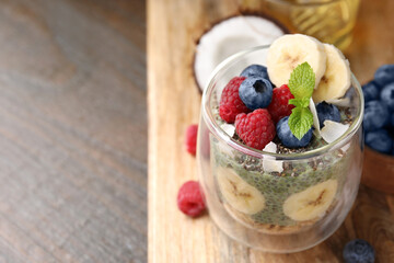 Tasty oatmeal with chia matcha pudding and fruits on wooden table, space for text. Healthy breakfast