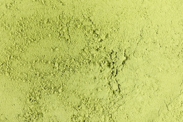 Green matcha powder as background, top view