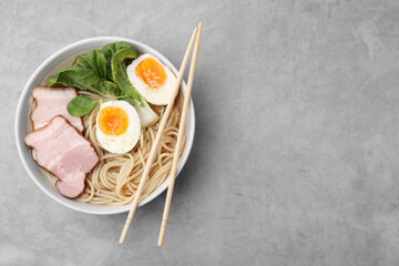 Delicious ramen with meat on light grey table, top view and space for text. Noodle soup