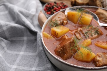 Delicious goulash in bowl on table, closeup. Space for text