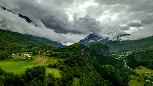 Drone hyperlapse of puffy clouds at mountain tops of lush valley, Aarset, Norway