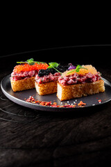 Canape with brioche, Raw beef meat tartar, salmon red caviar.