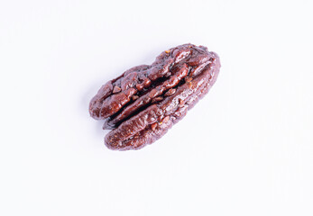 Roasted caramelized pecan nut on a white background, top view. Closeup