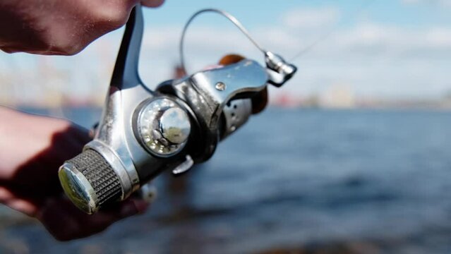 The line is wound on a reel. fisherman catches fish on the river.