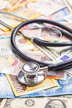 Stethoscope on various banknotes background.