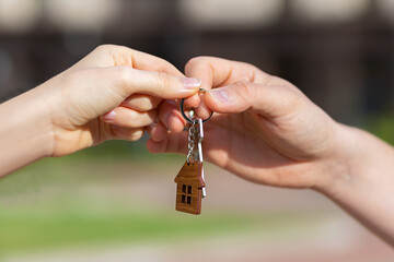 Man woman handing key keychain of home. Male female hand hold housekey in hand. Buy sale rent real estate. mortgage, apartment renting, moving, relocation, property. handing key