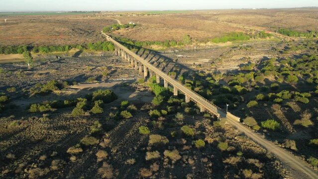 Fly along old steel wagon bridge which spans wide riverbed of Orange River, South Africa