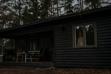 Female ghost seen through window of haunted cabin