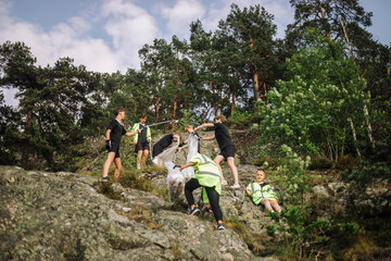 Low angle view of boys collecting garbage from rock formation