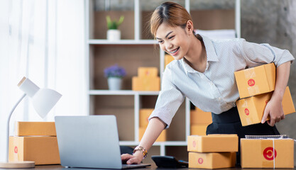 Young Asian girl Entrepreneurs, SME businesses check orders and check the purchase order Prepare parcels for asian businesswoman running an e-commerce Sme small delivery.