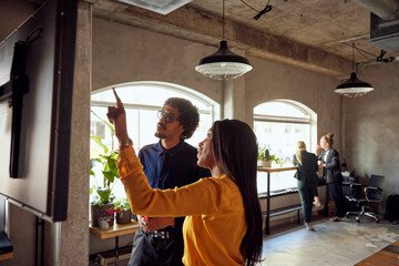 Businesswoman gesturing while discussing with businessman at creative office