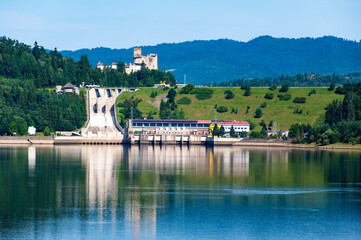 Poland. Niedzica ground dam on the Dunajec River, hydroelectric power plant and its water reflection in the lower artificial retention lake. Medieval Niedzica castle in the background