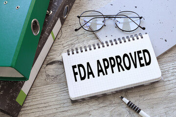 FDA Approved text on white notepad paper near folders