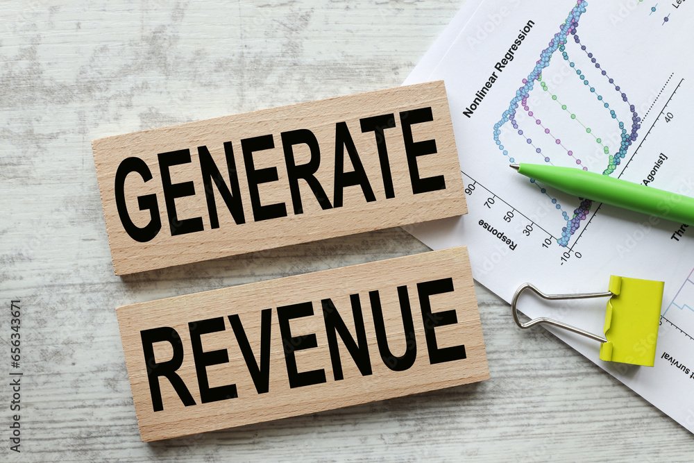 Poster generate revenue. wooden blocks with text on the office table.