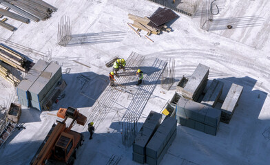 Top view: builders working with a metal rebars at the construction site