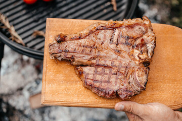 Dry Aged Barbecue Porterhouse Steak T-bone beef steak sliced with large fillet piece with herbs and...