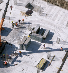 Workers in orange and yellow uniform at the construction site on gray background