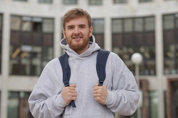 Portrait of young man university or college student at campus outdoors with backpack 