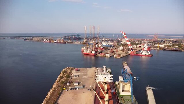 Aerial drone footage of a Jackup drill rig docked for maintenance and repairs. Oil discovery platform at a port filmed from above.
