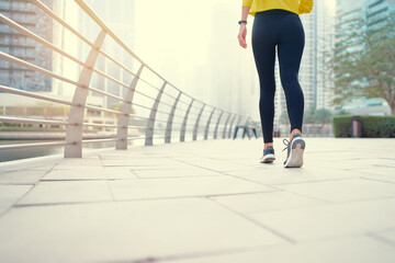 Sport concept. Healthy lifestyle. Young woman exercising on city embankment. Female feet in sneakers outdoor.