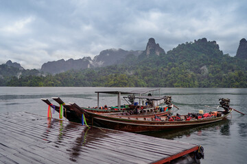 Traditional wooden boats on wharf in Cheow Lan Lake, Khao sok national park, Thailand.